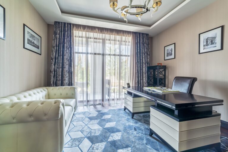 Панорамное окно кабинета, оформленное белым тюлем и узорчатыми серыми шторами