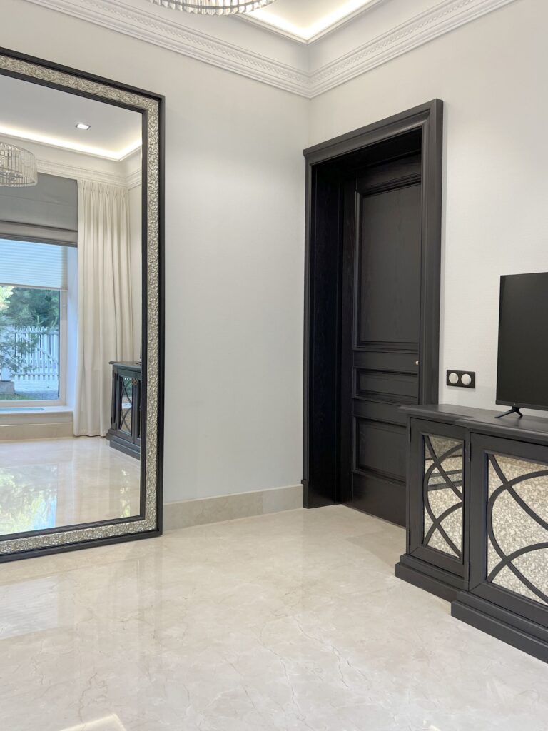 Дизайн гостиной со светлым мрамором и темными дверьми