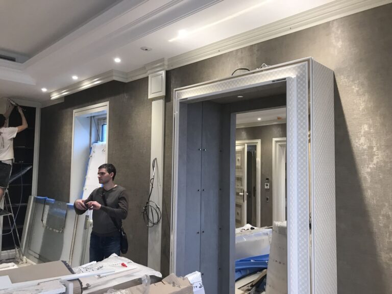 Белый портал с позолоченной окантовкой в оформлении дверного проема