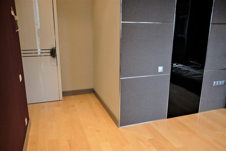 Стеновые панели в серой текстильной обивке с серебристыми розетками и выключателями