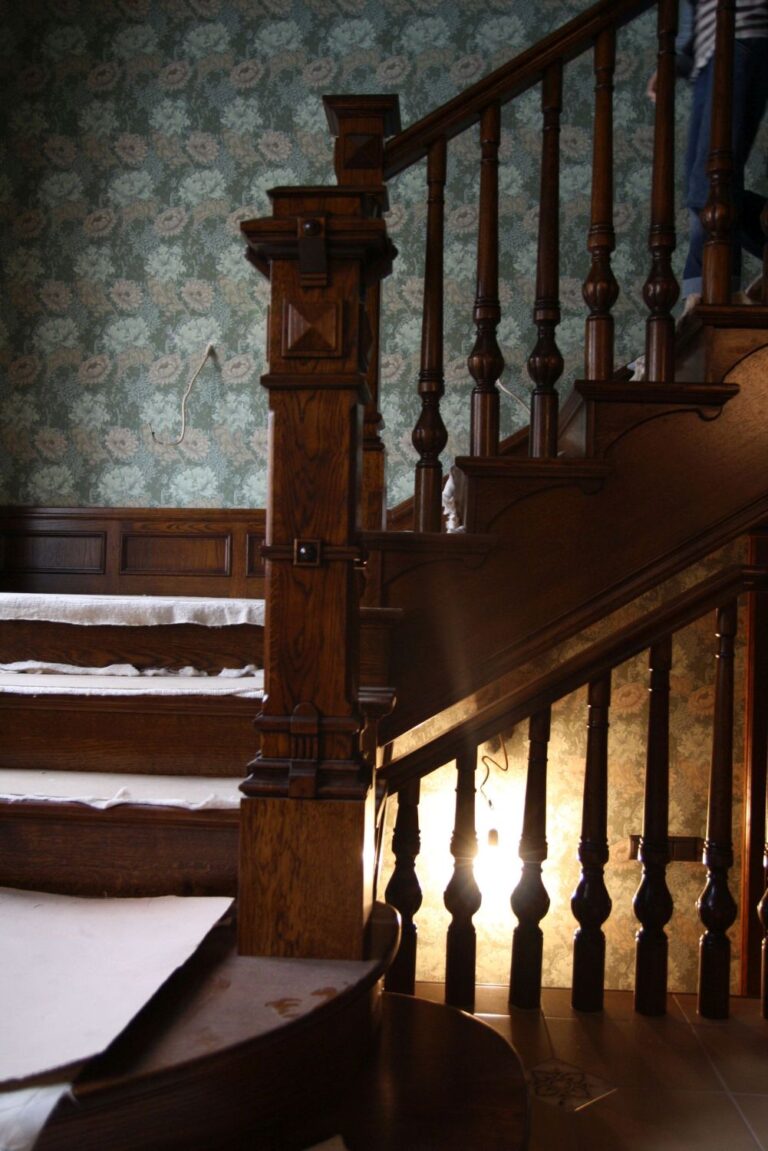 Особняк после ремонта с классической деревянной лестницей