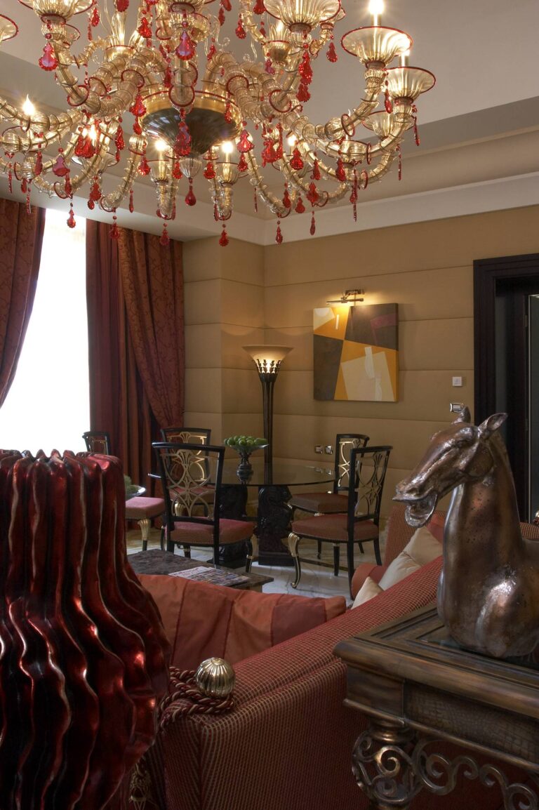 Яркий дизайн гостиной с золотистой многорожковой люстрой