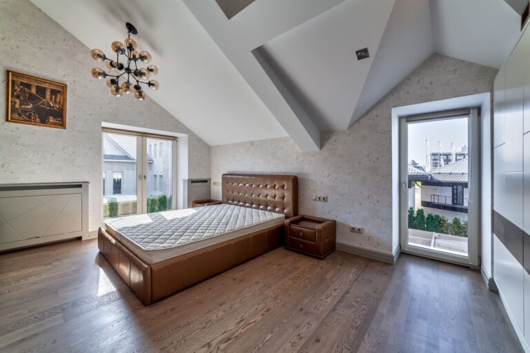 Светло-серая спальня с кроватью и тумбами шоколадного оттенка