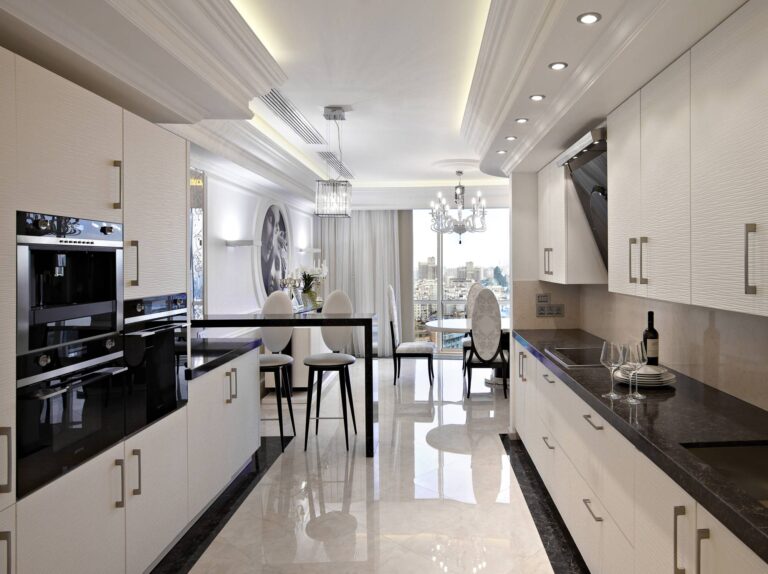 Темная столешница из мрамора в дизайне нежно-кремовой кухни