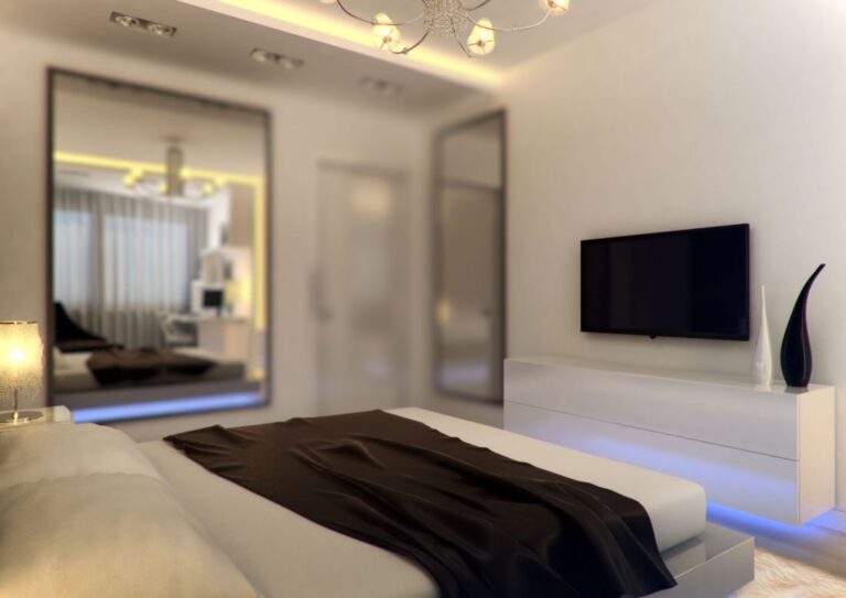 Тумба для телевизора в белых тонах с голубой подсветкой в оформлении спальни