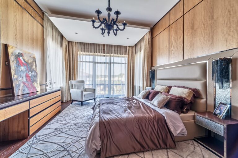 Кремовые шторы и белый тюль в оформлении панорамных окон спальни