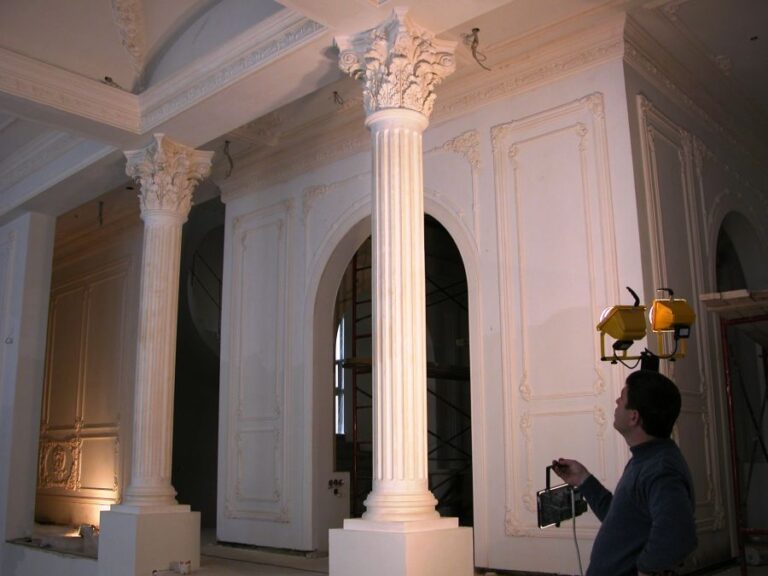 Зал коттеджа после ремонта с белыми классическими колоннами