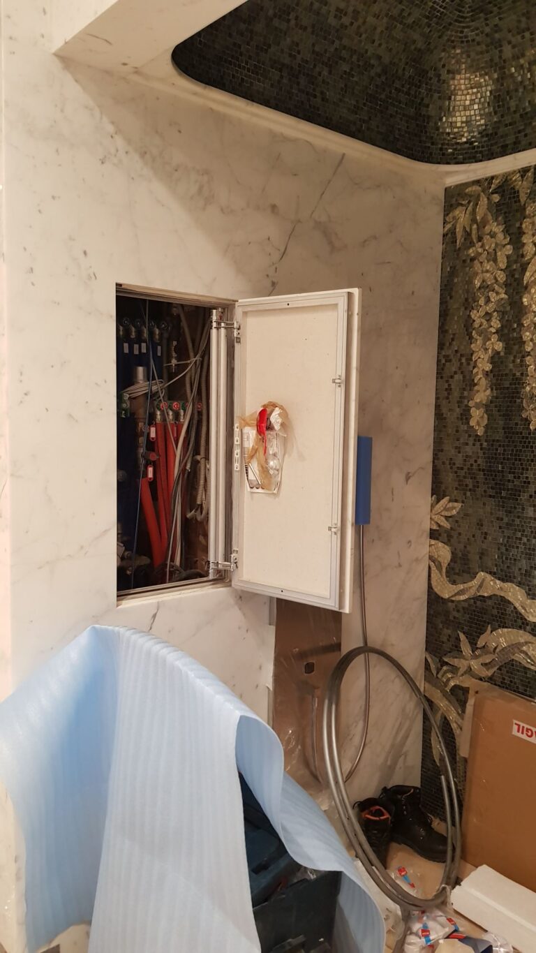 Санузел с техническим отсеком за распашной мраморной дверкой