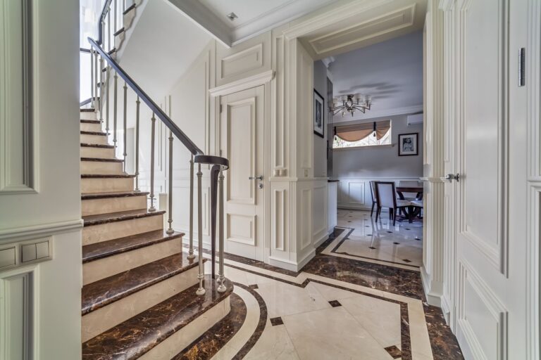 Палевый и коричневый мрамор в интерьере белого лестничного пролета