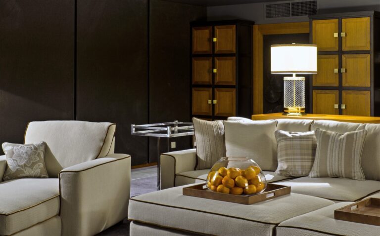 Светло-серая мягкая мебель с ореховыми шкафами в дизайне гостиной