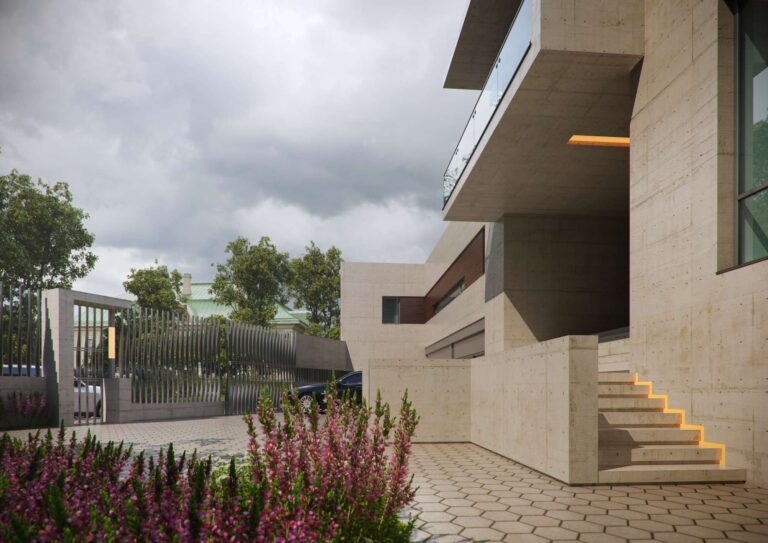 Левый фасад дома в светлой отделке и парковка, выложенная тротуарной плиткой