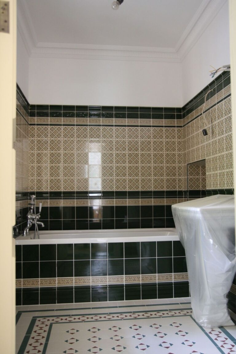 Черный фриз на коричневой плитке в отремонтированной ванной