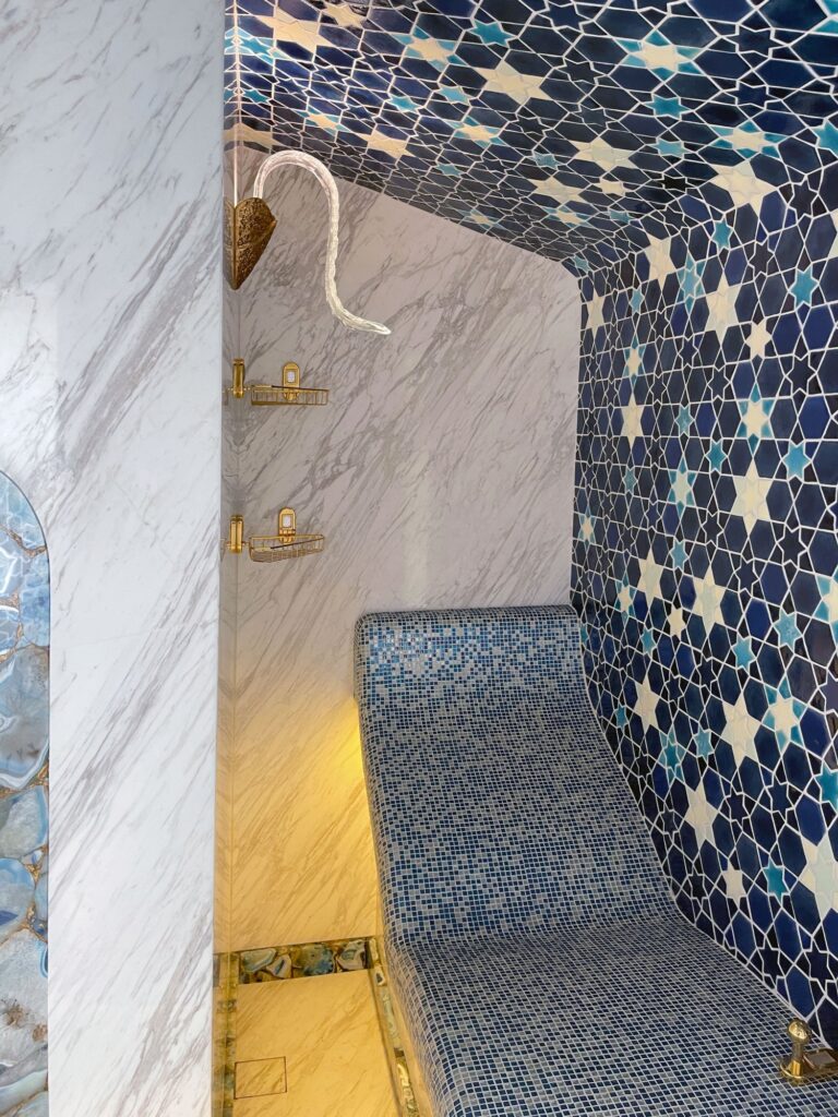 Интерьер большой душевой с удобным местом для отдыха