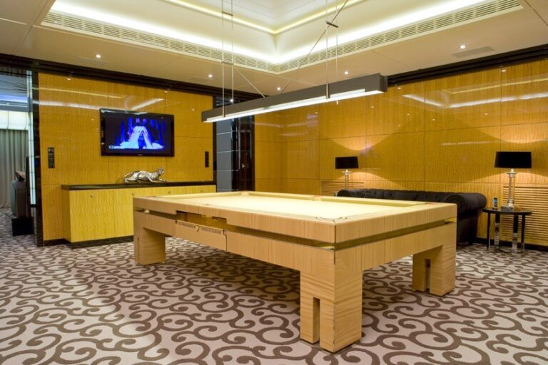 Яркие желтые стены в дизайне бильярдной комнаты