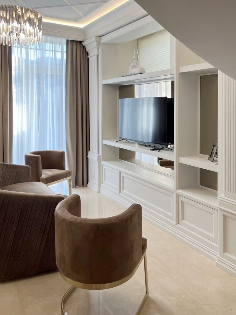 Интерьер гостиной с белыми шкафами