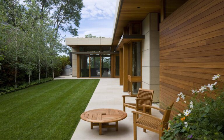 Круглый деревянный столик и стулья в дизайне террасы