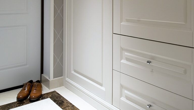 Серый холл с белыми шкафами и дверью