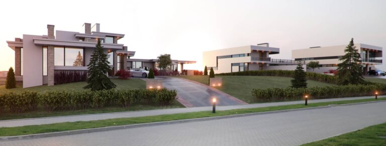 Общий вид на коттедж белого цвета и прилегающую территорию