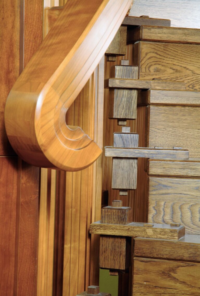 Винтовая лестница из орехового массива с изогнутыми перилами