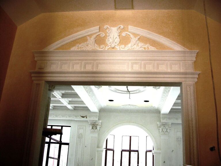 Белый дверной портал с лепными элементами в оформлении дома