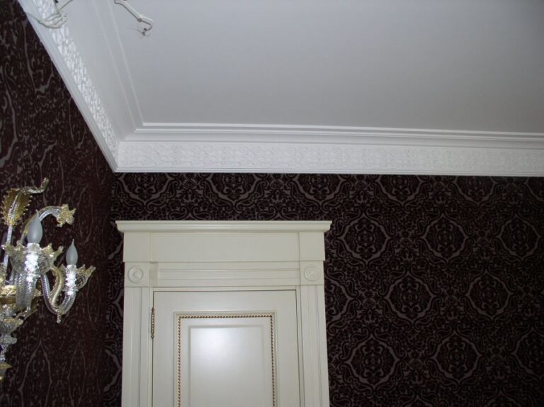 Узкий портал двери из белого дерева в оформлении комнаты