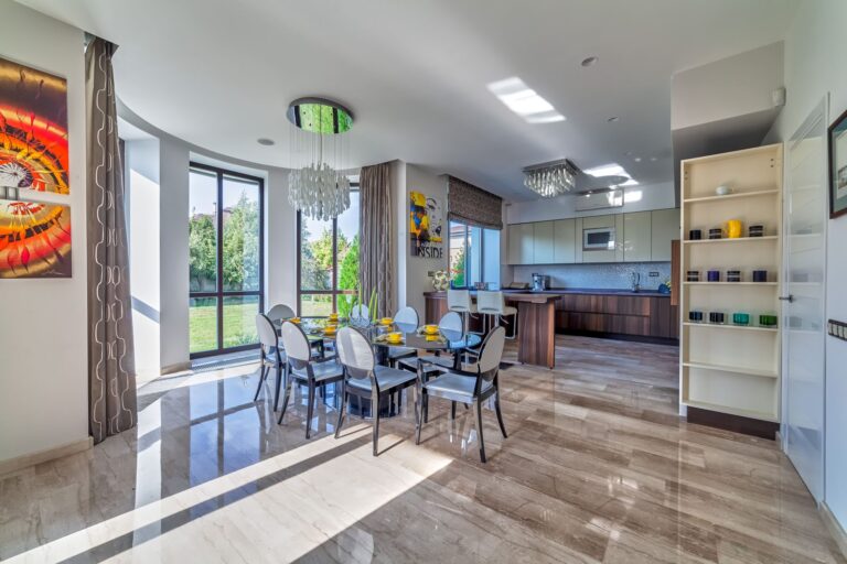 Бежевый мраморный пол и панорамные окна в интерьере столовой и кухни