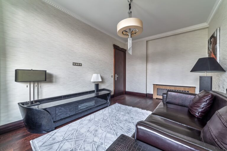 Кожаный диван цвета венге в светло-серой гостевой комнате