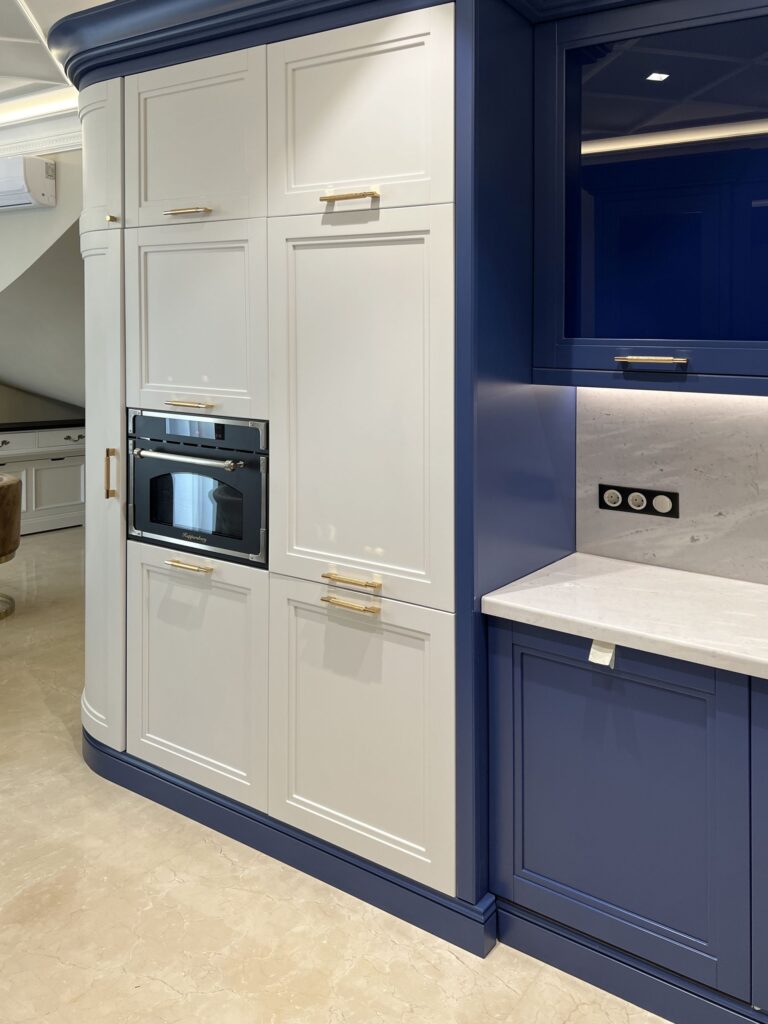 Золотистые ручки в бело-синей кухне