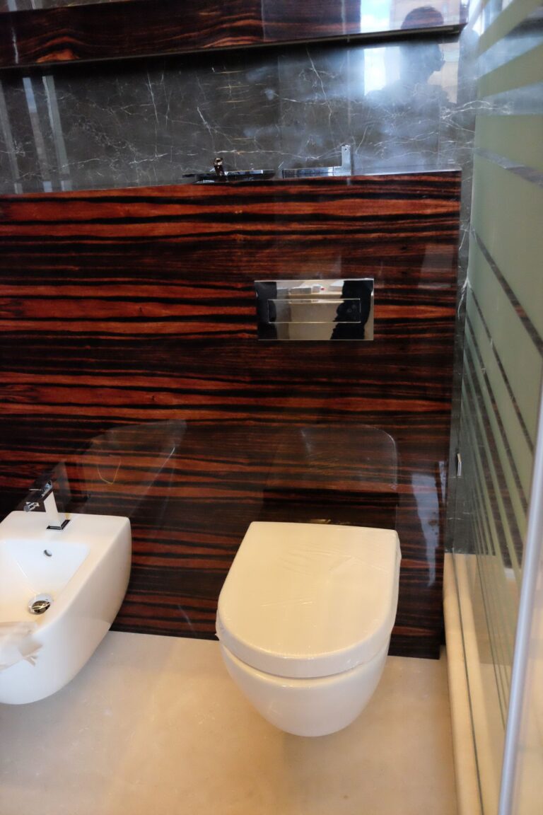 Санузел с полированными стеновыми панелями из зебрано