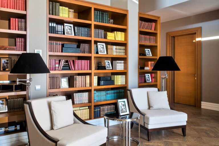 Библиотека с открытым книжным шкафом и серыми креслами