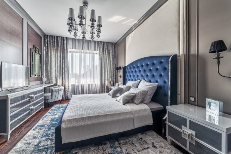 Кровать в синей бархатной обивке в дизайне светло-серой спальни