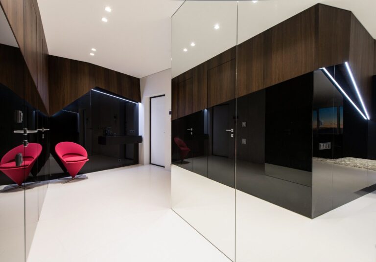 Дизайн прихожей с коричневыми дубовыми и черными зеркальными панелями и встроенными шкафами