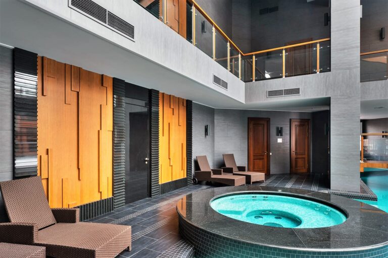 Декоративные панели и плетеные шезлонги в интерьере бассейна