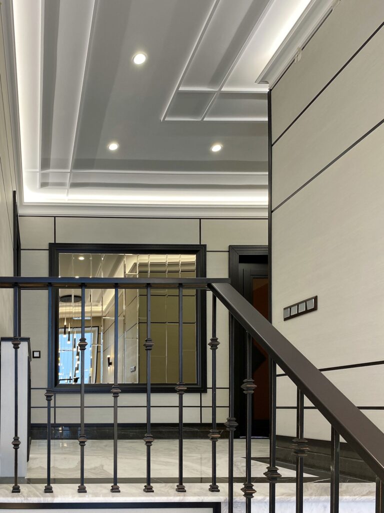 Дизайн лестничного холла с большим квадратным зеркалом