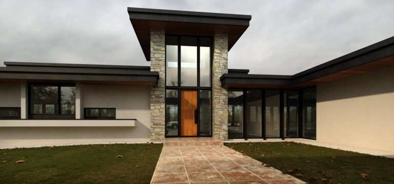 Светлая отделка и камень в фасаде дома с панорамными окнами